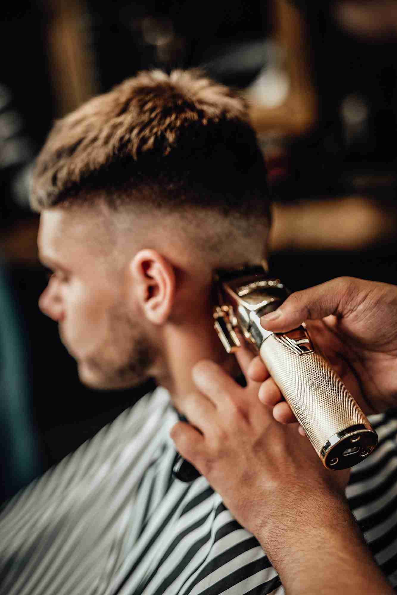 Barber applying finishing touches to a stylish haircut in Anchorage.